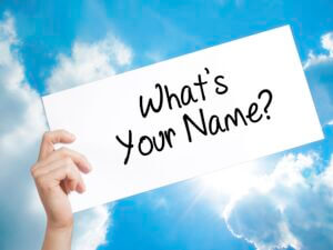 miles marketing What's your Name? Sign on white paper. Man Hand Holding Paper with text. Isolated on sky background.  Business concept. 